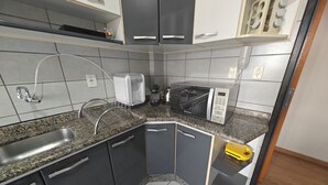 A kitchen with granite countertops, a built-in microwave, a sink, and a toaster.