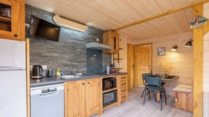A modern kitchen with wooden cabinets, a stone backsplash, and a built-in oven. - Mont Blanc chain view / hike / relaxation (Les Houches)