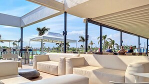 Un salón en la azotea con asientos exteriores y vistas a la piscina.