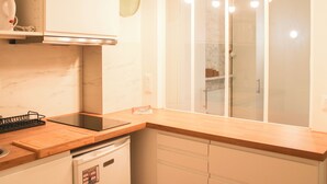 Une cuisine moderne dotée d’un plan de travail en bois, d’une cuisinière encastrée et d’un lave-vaisselle.
