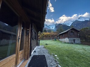 Una cabaña de madera con vistas a montañas nevadas.