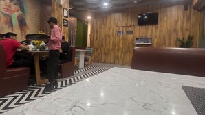 Ein Restaurant mit einer Holzwand, einem Fernseher und einem Marmorboden.