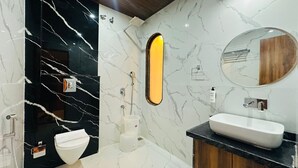 Ein modernes Badezimmer mit einem Schwarz-Weiß-Marmor-Design, einem weißen Waschbecken und einer Toilette.