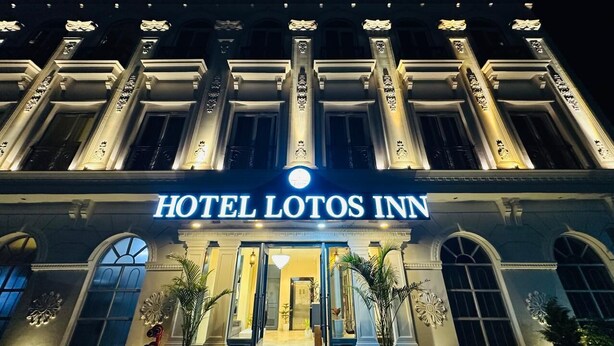 Das Hotel Lotos Inn mit klassischer Architektur, darunter Säulen und Rundbogenfenster.