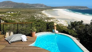 Un espace piscine offrant une vue sur la plage et les montagnes.