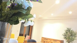 A dining area with a wooden table, black and white chairs, and a potted plant. - Large 4-bedroom apartment in fantastic Sliema: WiFi, AC -5 min to the Sea-  8ppl (Sliema)