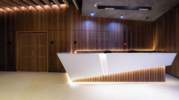A modern reception area with a wooden finish, a reception desk, and a ceiling with recessed lighting.