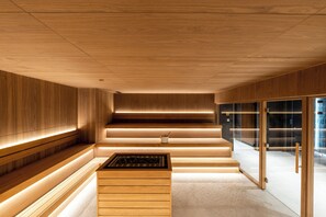 A modern interior with wooden paneling, a central staircase, and a glass partition. - Woodside Apartment 218 (Raška)