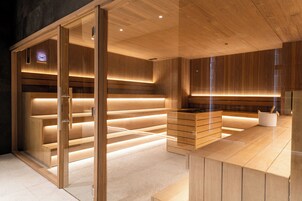Una habitación moderna y luminosa con paneles de madera, una partición de vidrio y un banco integrado.