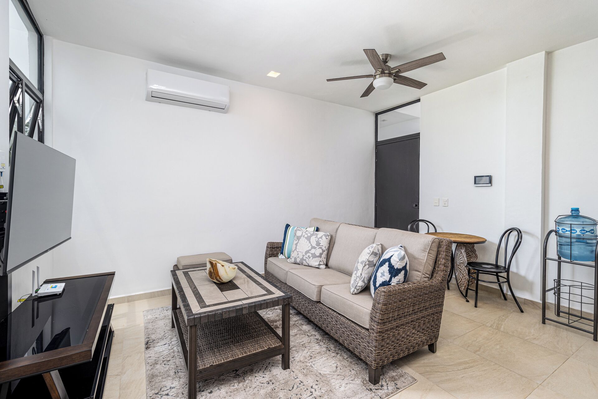 Un salon moderne avec un canapé, une table basse et un ventilateur de plafond.