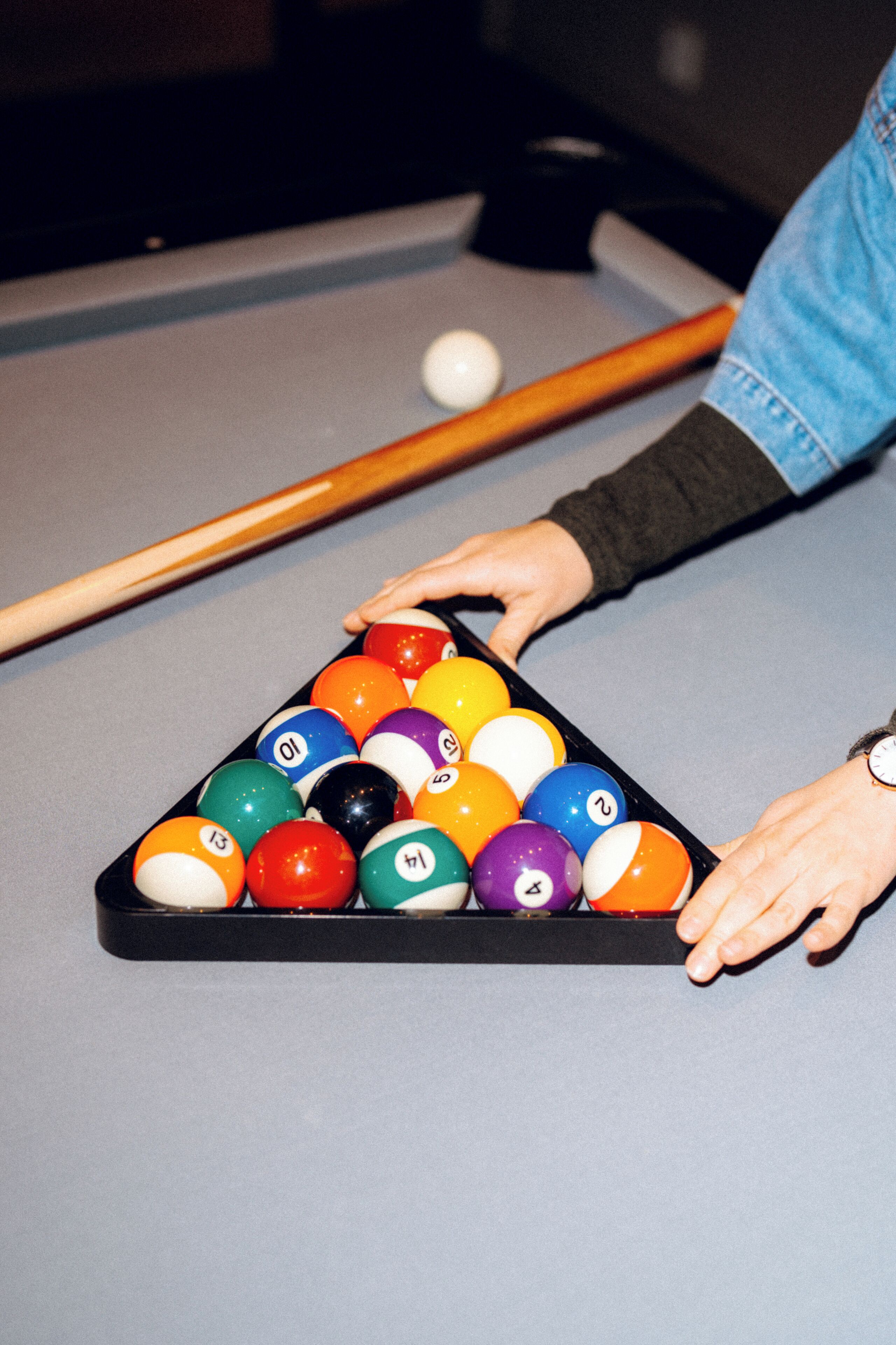 A pool table with a triangular rack of billiard balls.