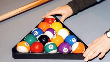 A pool table with a triangular rack of billiard balls.