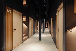 A corridor with wooden doors, each marked with a number.