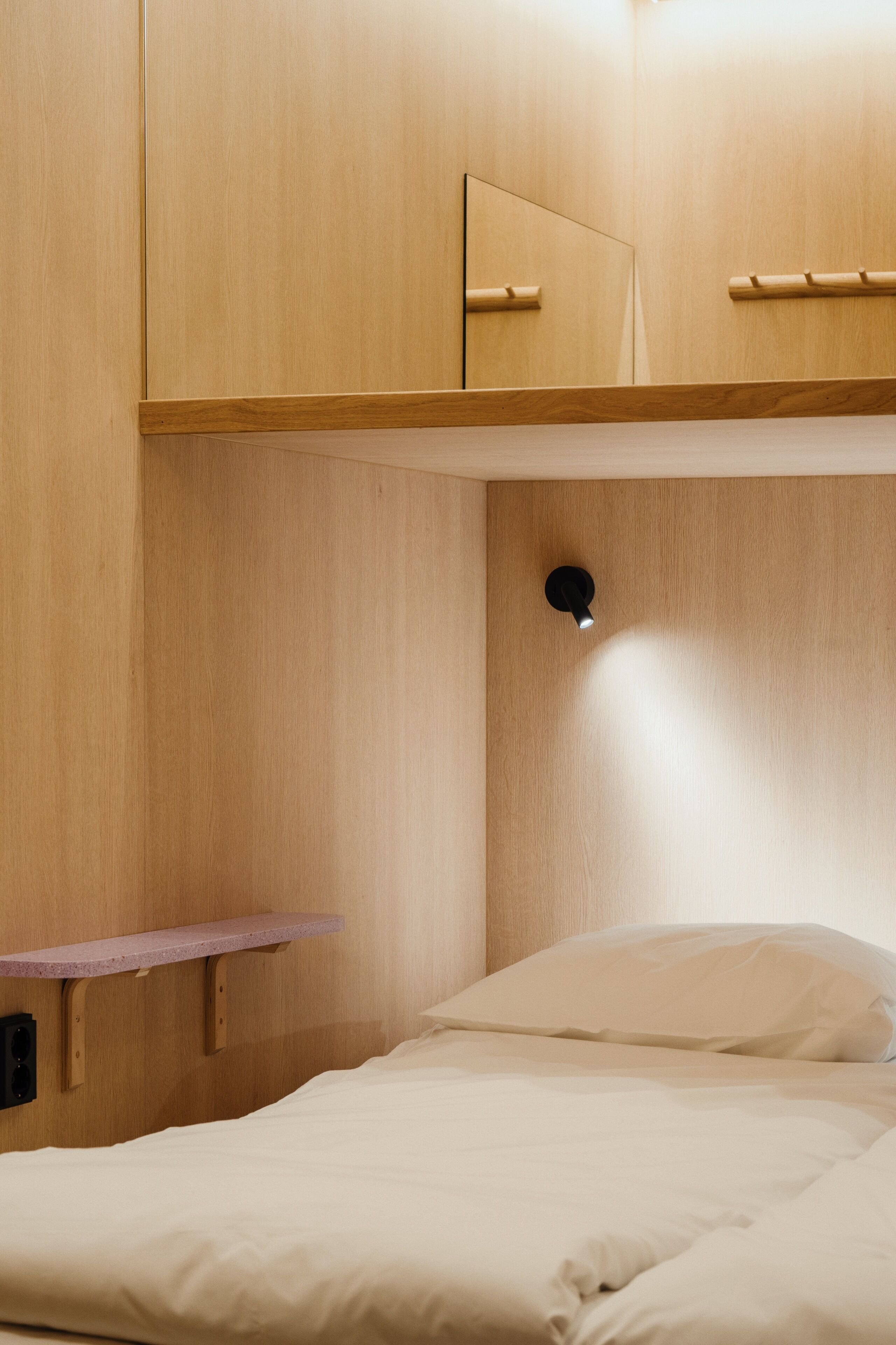 Une chambre à coucher avec un lit, une armoire en bois et une petite étagère.