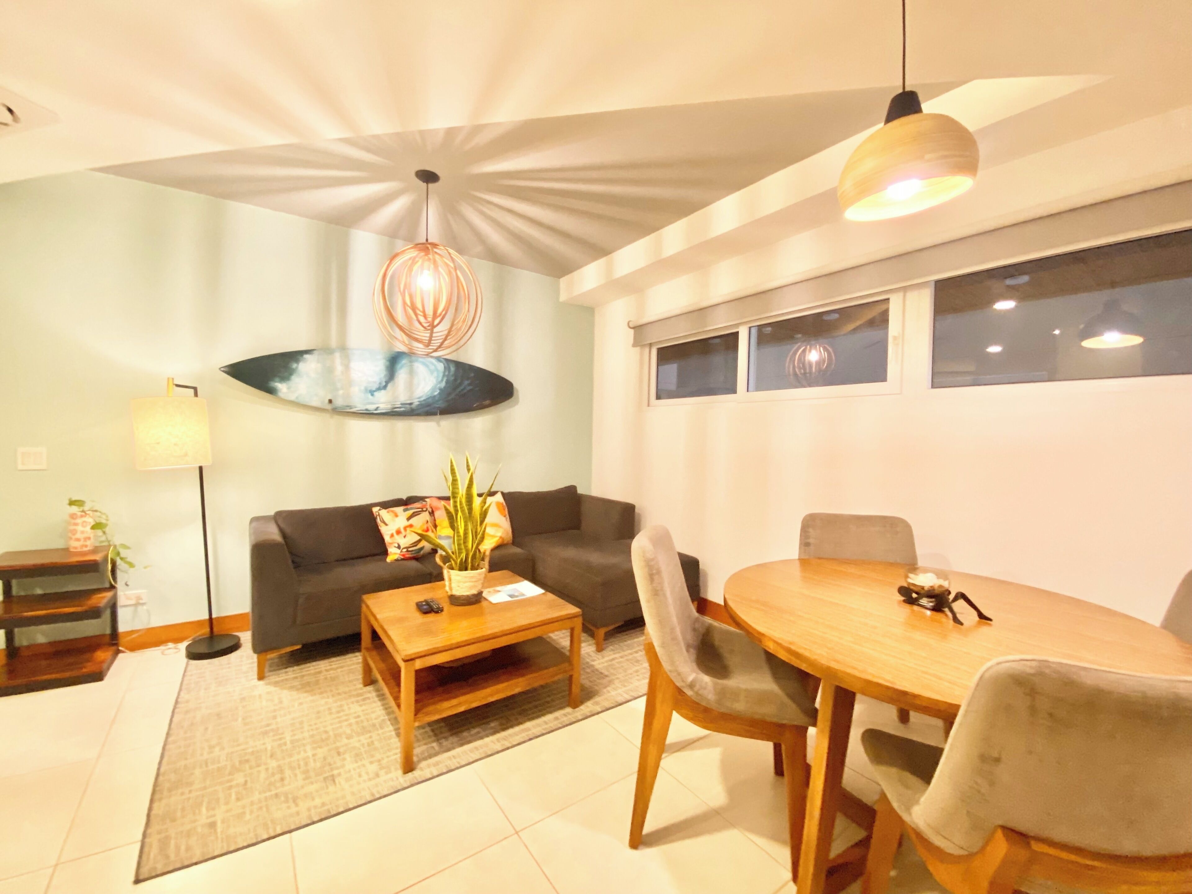Een moderne woonkamer met een bank, salontafel en eettafel.