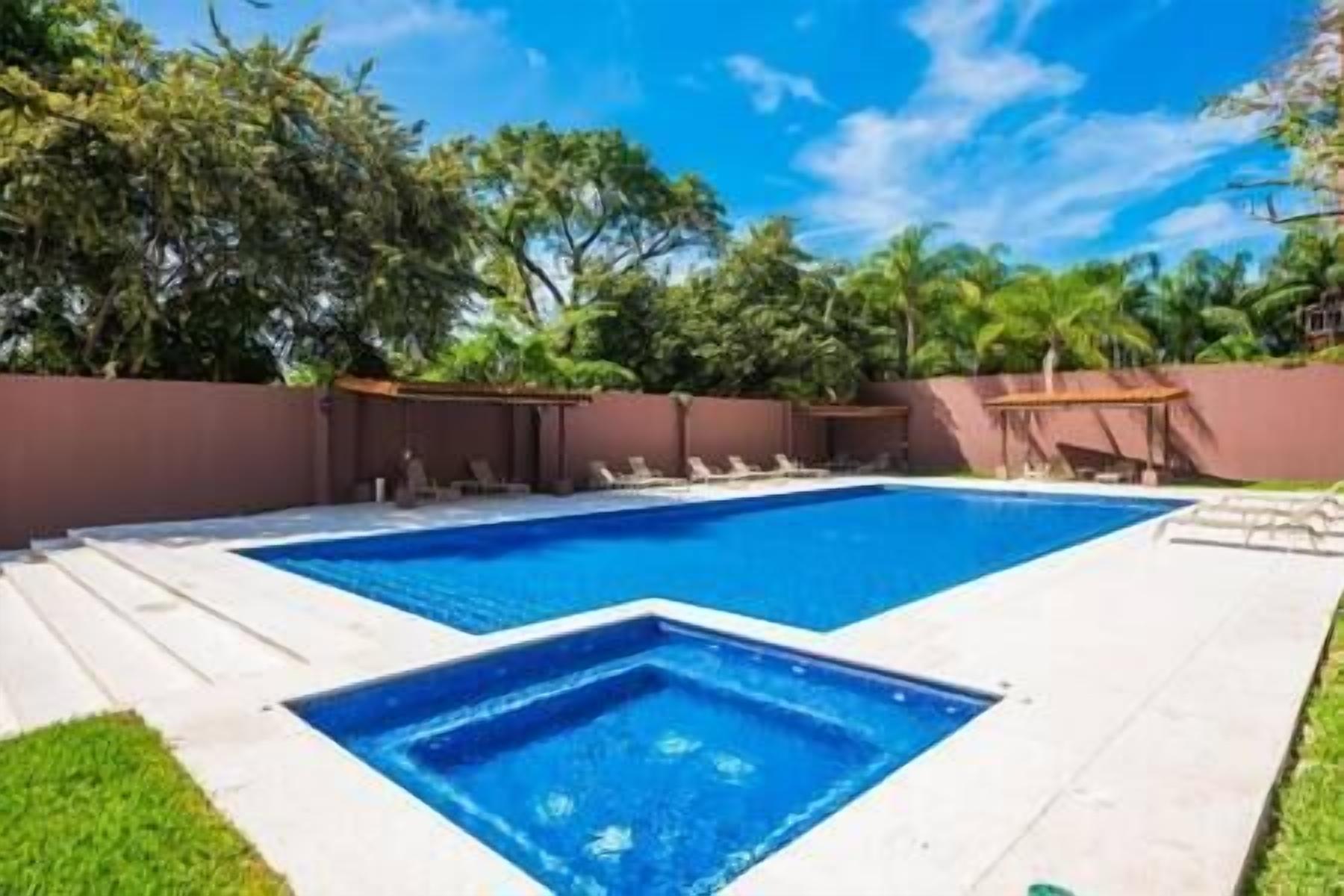 A rectangular pool with two separate sections, surrounded by a low brick wall and a wooden deck.