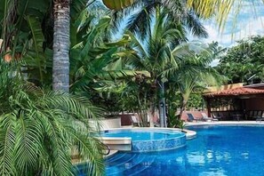 Una piscina rodeada de exuberante vegetación tropical.