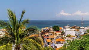 Une ville côtière avec des bâtiments, un ciel dégagé et la mer.