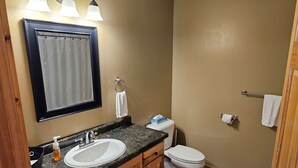 Een badkamer met een wastafel, spiegel en toilet.