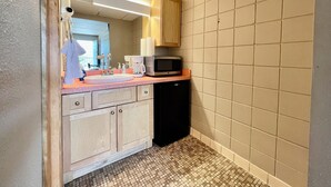 A compact kitchen with a sink, microwave, and coffee maker. - Downtown CF Studio - Free Gated Parking! 520 (Cedar Falls)