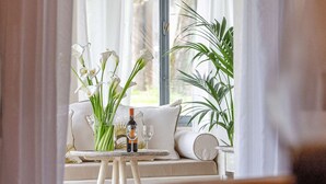 Un coin salon accueillant avec un canapé et une petite table, une bouteille de vin et un verre, créant une atmosphère détendue.