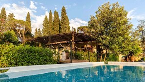 Une piscine agrémentée d’une pergola et d’une végétation luxuriante.