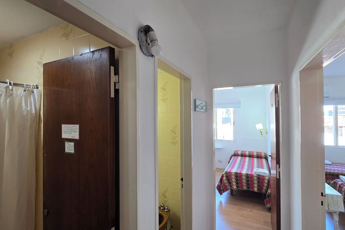 Ein Zimmer mit einem Bett, einem kleinen Tisch und einem Fenster.