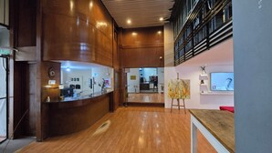 Un espace d’accueil avec un comptoir en bois, un ordinateur et un panneau indiquant « OCCUPÉ ».