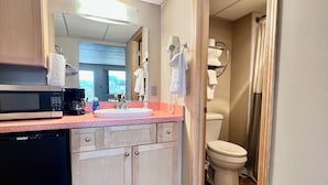 Une salle de bain moderne équipée de toilettes, d’une douche et d’un espace lavabo.