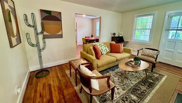 A living room with a sofa, armchairs, a coffee table, and a patterned rug. - Tea Olive Cottage - 2BR Near Augusta National, Downtown & Medical District (Augusta)
