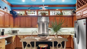 Une cuisine avec des meubles en bois, un réfrigérateur en acier inoxydable, un four à micro-ondes et un évier.