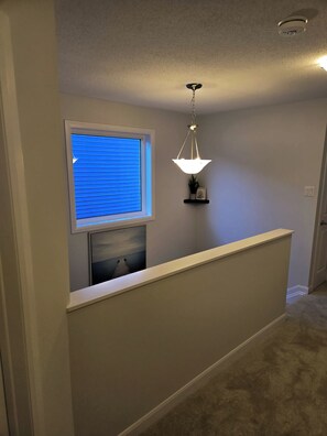 Stylish hallway with a window, shelf, and door.