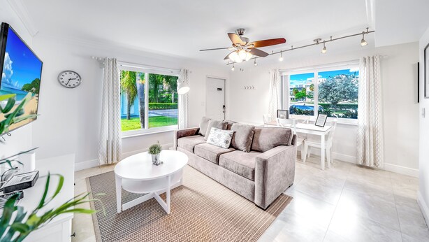 Un salon moderne avec un canapé, une table à manger et un ventilateur de plafond.