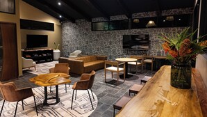 A modern lounge area with a sofa, chairs, a coffee table, and a bar.