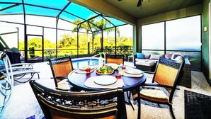 An outdoor dining area with a round table, chairs, and a ceiling fan. - 5 bdrm5, ensuites, Pool, free Grill, Solterra4695

 (Davenport)