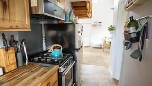 Uma cozinha com armários de madeira, fogão a gás e chaleira.