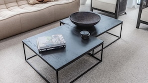En moderne stue med en sofa, et sofabord med en skål og en bog med titlen 'STYLE HERITAGE MODERN'.
