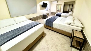 Una camera d'albergo con due letti, una TV, uno specchio e un tavolino.