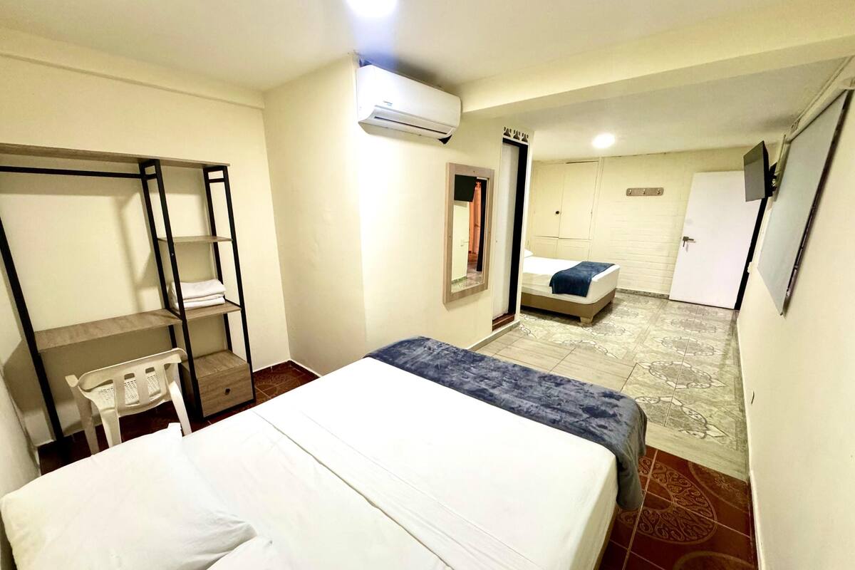 Ein Hotelzimmer mit Bett, Schreibtisch, Stuhl, Kleiderschrank und einer kleinen Sitzecke mit Sofa und Tisch.