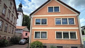 A multi-story building with a symmetrical facade, large windows, and a visible number '22' on the side. - Vacation apartment zur Linde II (Altertheim)