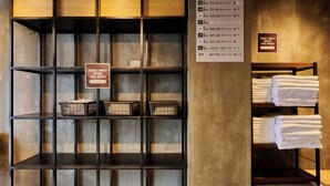 Habitación de hotel con guía de piso, un cartel que dice 'Solo toma lo que necesites' y estantes con toallas y cestas.