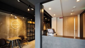 Una moderna zona de recepción con mostrador, asientos y un cartel que dice 