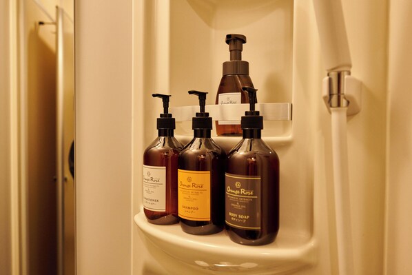 Estante de baño con tres botellas de productos de cuidado corporal Orange Rose.