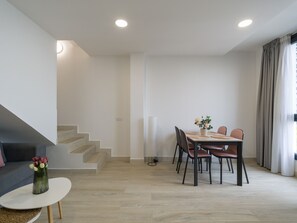 Un comedor moderno con una mesa, sillas y un jarrón de flores.