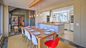 Eine moderne Küche mit Essbereich, einem Holztisch und Stühlen.
