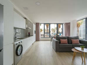 Eine moderne Wohnung mit Küche, Wohnbereich und großen Fenstern.
