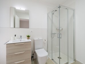 Chuveiro, secador de cabelo, toalhas de banho, papel higiênico