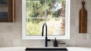 A kitchen with a window, a sink, and cabinets. - Loki’s Loft and Cellar (Kaslo)