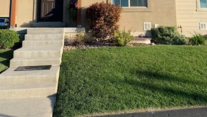 A two-story house with a front porch, a mailbox, and a well-maintained lawn.