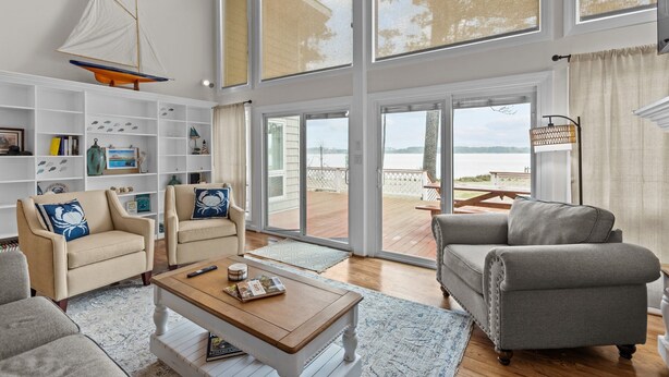 Ein geräumiges Wohnzimmer mit großem Fenster, einer Bootsdekoration und Blick auf das Deck.
